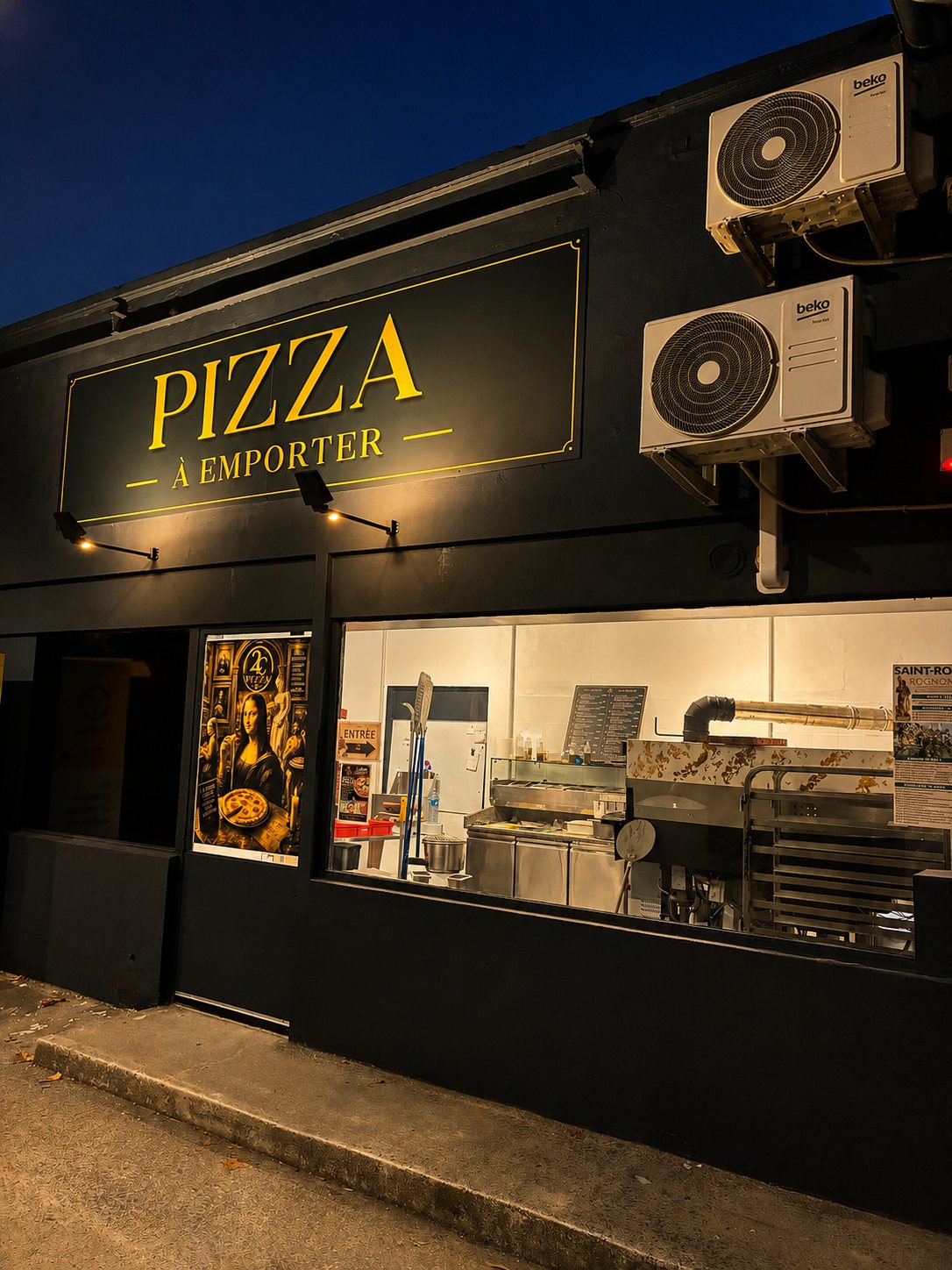 Devanture noire de nuit, enseigne « Pizza à emporter » en lettres dorées