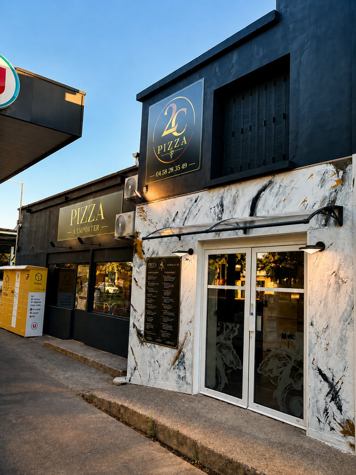 La façade de jour : panneau 2C Pizza doré, marbre blanc et porte vitrée